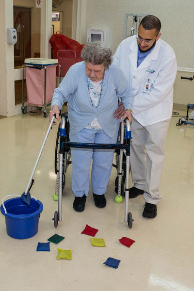caregiver and elderly woman doing rehab