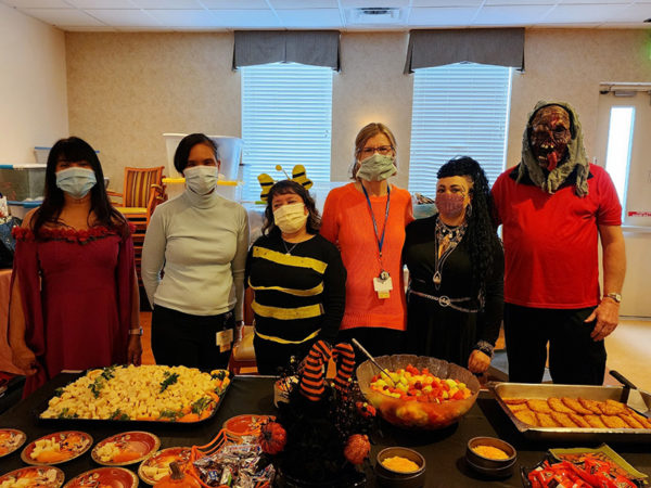 staff standing in front of halloween party buffet